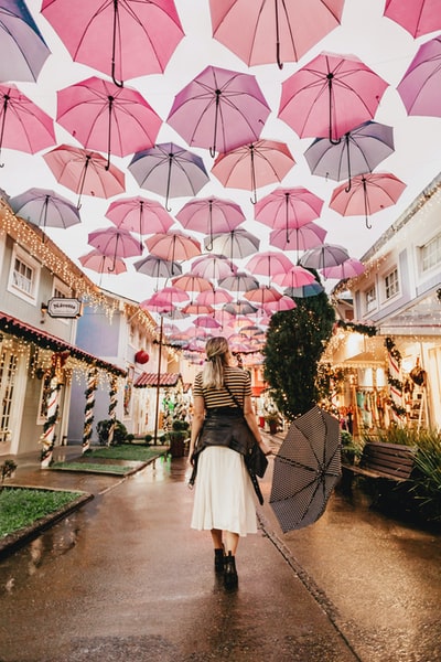 女人站在粉红色的雨伞
